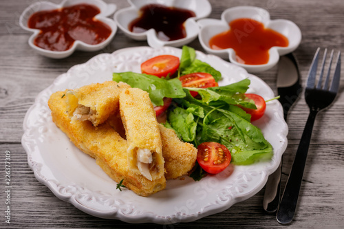 Fish sticks fried in breadcrumbs with sauces