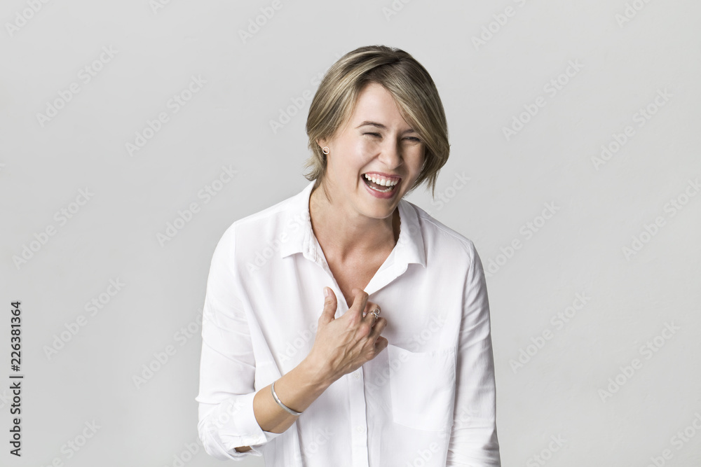 Happy young blonde woman wearing white shirt smiling portrait against white background Happy young blonde woman wearing white shirt smiling portrait against white background