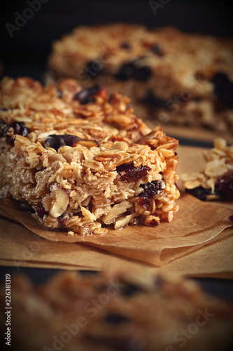 Homemade granola bars with nuts and cranberries over black background