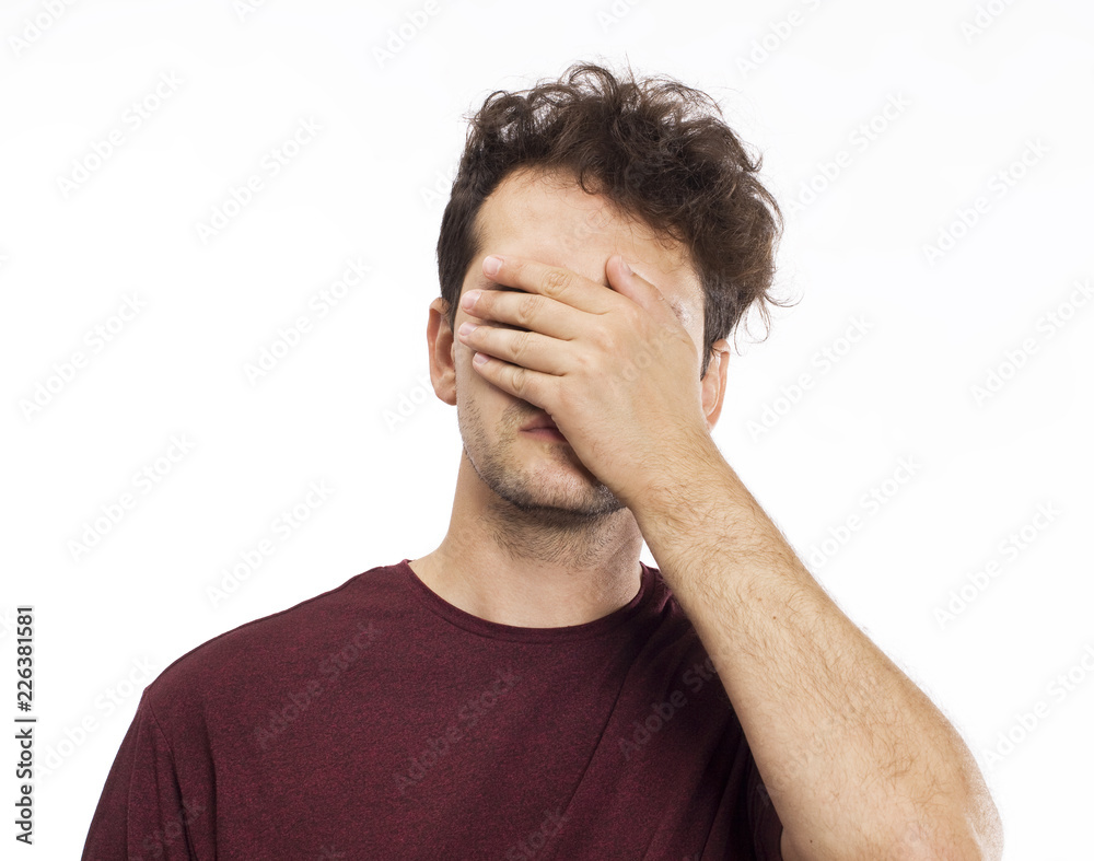 Young man blocking face with hands Young man blocking face with hands