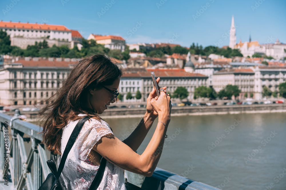 Beautiful girl is standing on a bridge