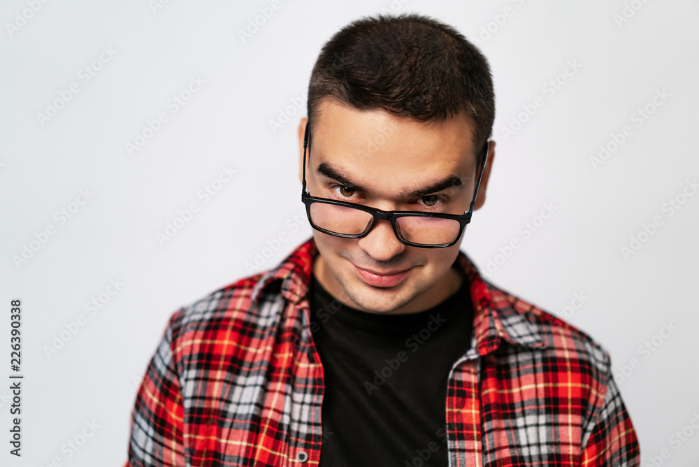 stylish glasses with black rim on a man in a plaid shirt in the studio on a white background. Close-up stylish glasses with black rim on a man in a plaid shirt in the studio on a white background. Close-up