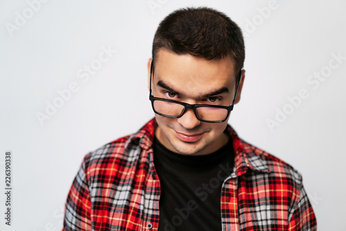 stylish glasses with black rim on a man in a plaid shirt in the studio on a white background. Close-up © Vadim