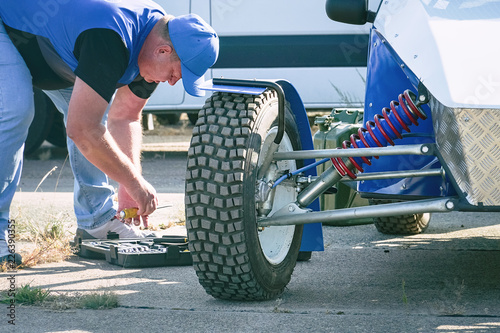 The mechanic serves the car. All-wheel drive off-road racing buggy car photo