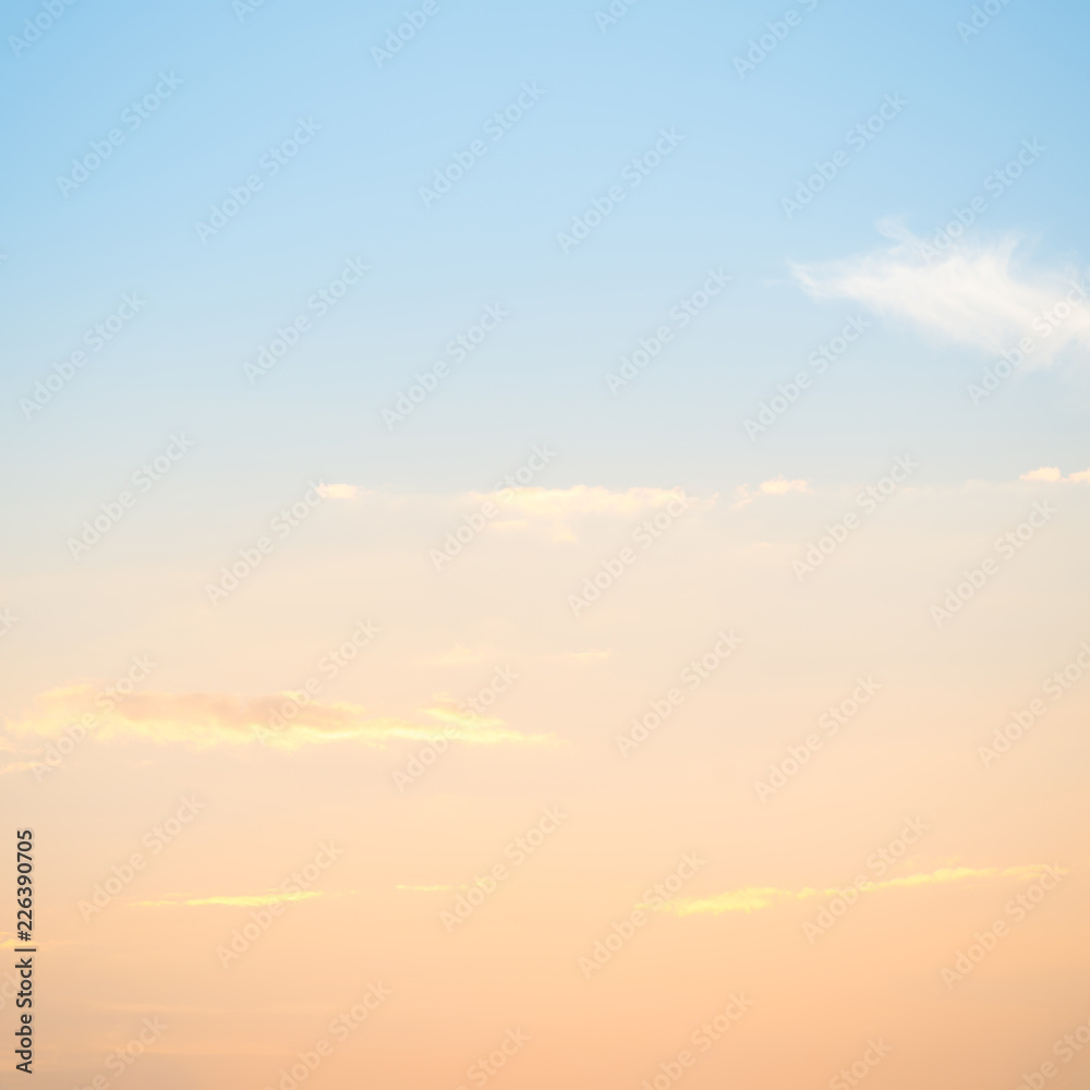 Obraz premium Zachód słońca ze słońcem i chmurami na pastelowym niebieskim i pomarańczowym niebie