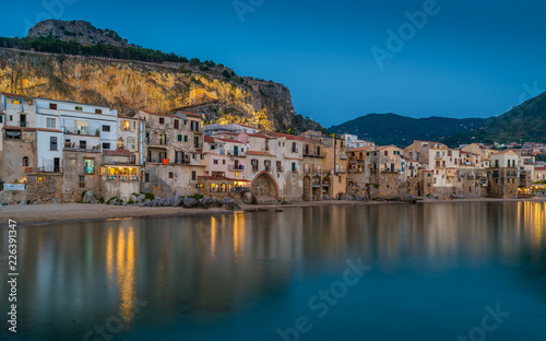 Cefalù waterfront in the evening, with lights reflecting on the water. Sicily, southern Italy.