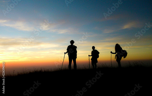 silhouette of hikers in sunset