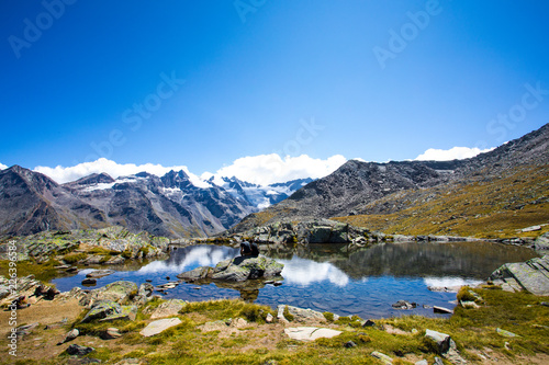 Alpy Gran Paradiso - górskie jezioro z odbiciami chmur - Cogne Aosta Valley - Park Narodowy Grand Paradis