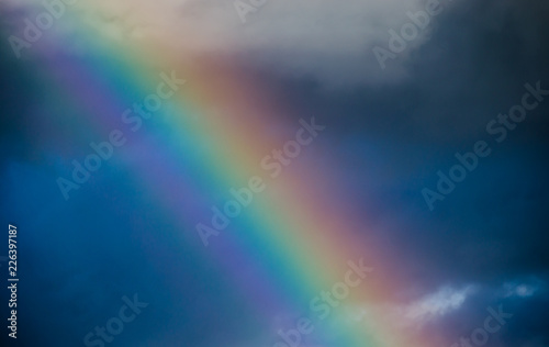 Rainbow in the dark blue sky close up