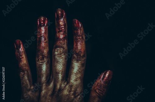 Bloody dirty zombie hand on black background. Halloween spooky poster
