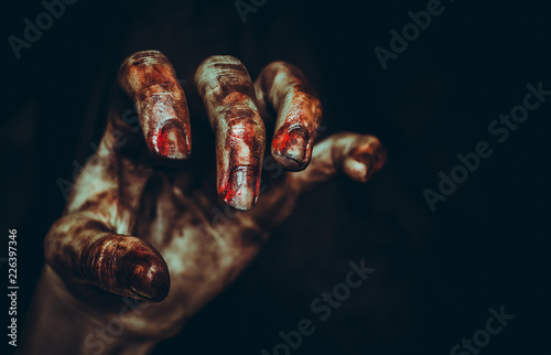 Bloody dirty zombie hand on black background. Halloween spooky poster