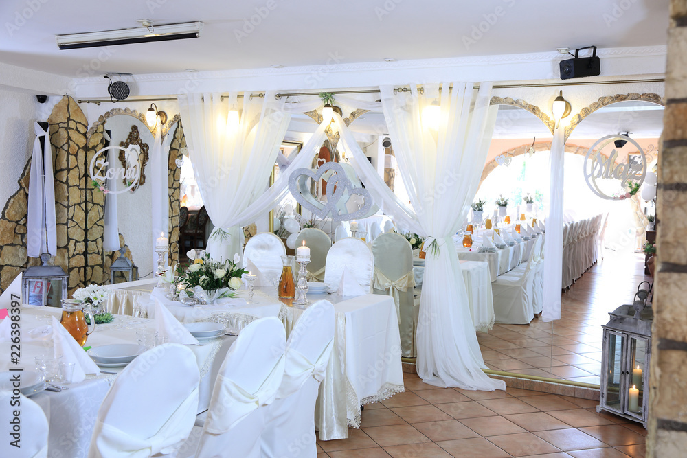 Ślub, wesele, stoły w restauracji nakryte na biało. 
