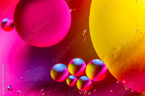 Abstract background with colorful gradient colors. Oil drops in water abstract psychedelic pattern image. Purple orange yellow colored abstract pattern with water bubbles photo