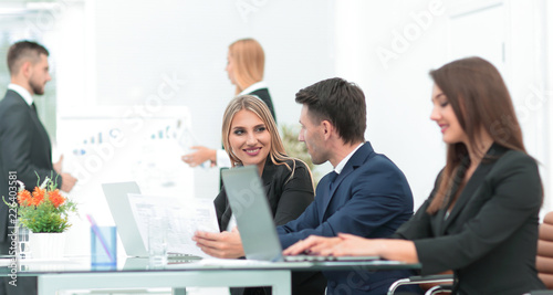 business team discussing new information , standing in front of the open laptop