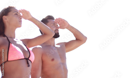 Young couple in swimsuits looking at the sea,
