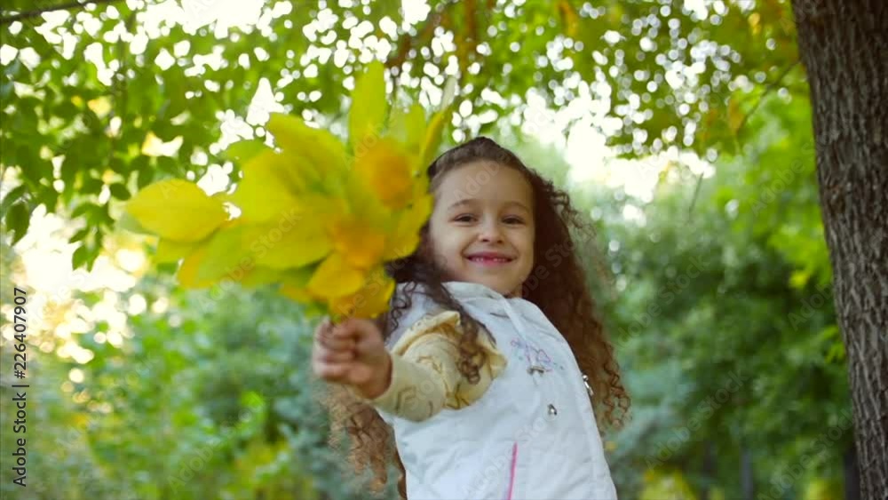 Beautiful Fashionable Happy Smiling Stylish Joyful European Little Cute Girl in a White Jacket Vest and Long Blonde Curly Hair Walks in the Autumn Park Enjoys Happy Playing with Autumn leaves, Running Beautiful Fashionable Happy Smiling Stylish Joyful European Little Cute Girl in a White Jacket Vest and Long Blonde Curly Hair Walks in the Autumn Park Enjoys Happy Playing with Autumn leaves, Running