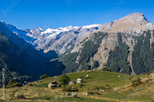 Cuadro en lienzo Mountain village rural houses with green fields and the Grand Paradise glacier at background