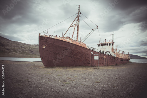 An old rusty  ship "Gardar" in Iceland on a background of a dramatic sky. Toning image © ozerkina