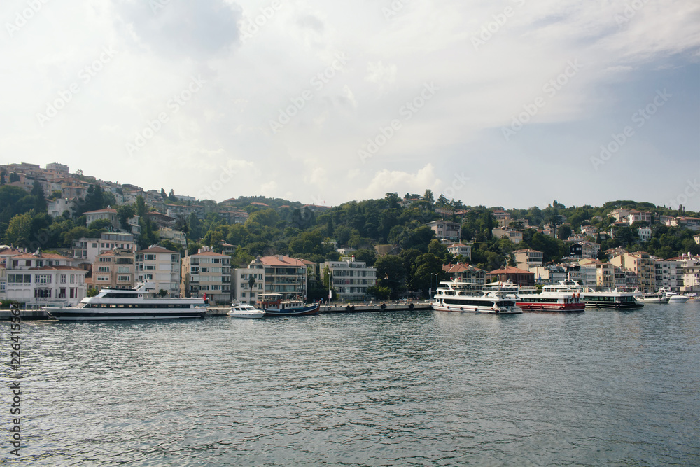 View of big motorboats, yachts, buildings on European side and Bosphorus in Istanbul.