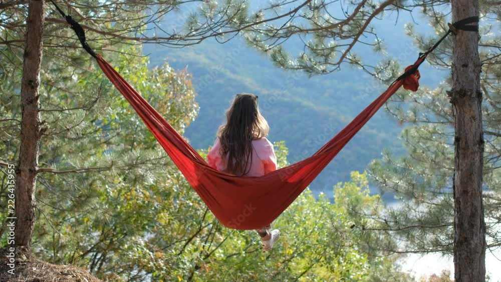 Young woman in hammock near lake