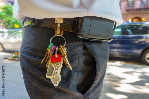 overweight worker with uniform and hanging access keys and cell phone clip