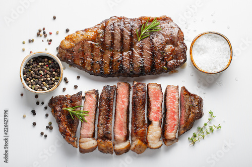 Fotografie Two grilled marbled beef steaks striploin with spices isolated on white backgrou