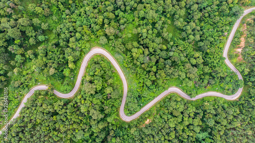 Tableau sur toile Aerial view of countryside road passing through the green forrest and mountain
