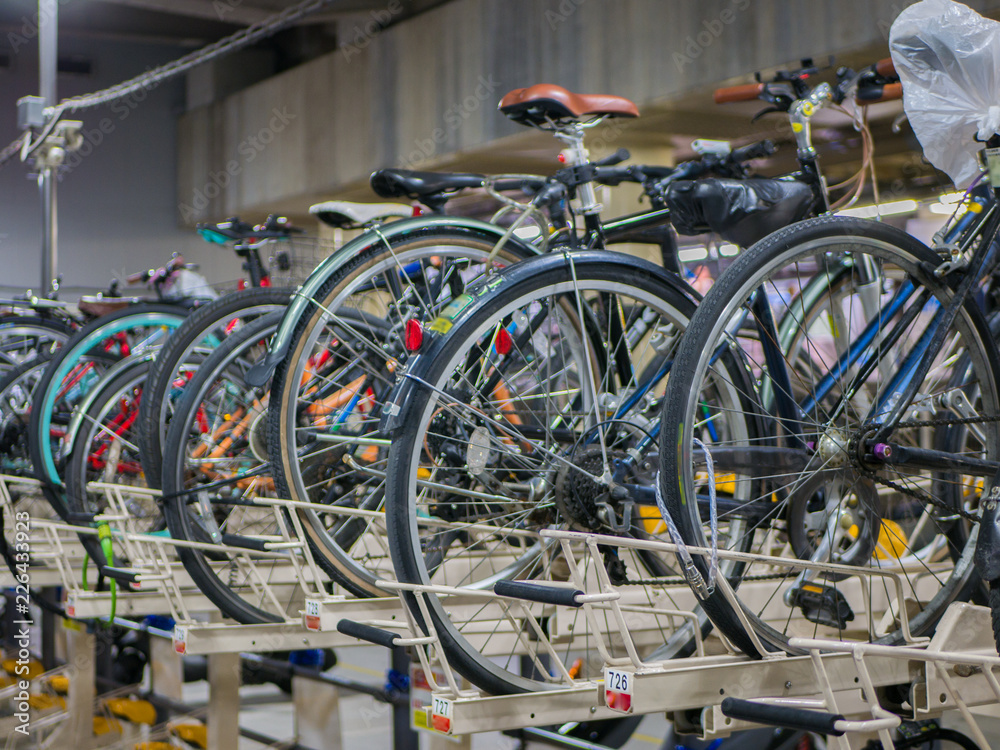 Tokyo, Japan - September 11, 2018. Two rows system of bicycles parking indoor garage near the Shinjuku train station. They be designed for less spaces, more useful concept.