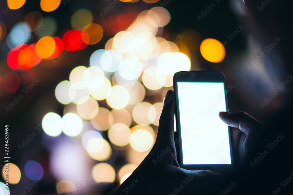 Soft focus man using his mobile phone in the street, night light bokeh Background,copy space. Soft focus man using his mobile phone in the street, night light bokeh Background,copy space.