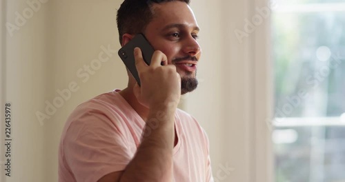 4K Smiling confident man talking on cell phone indoors. Slow motion.