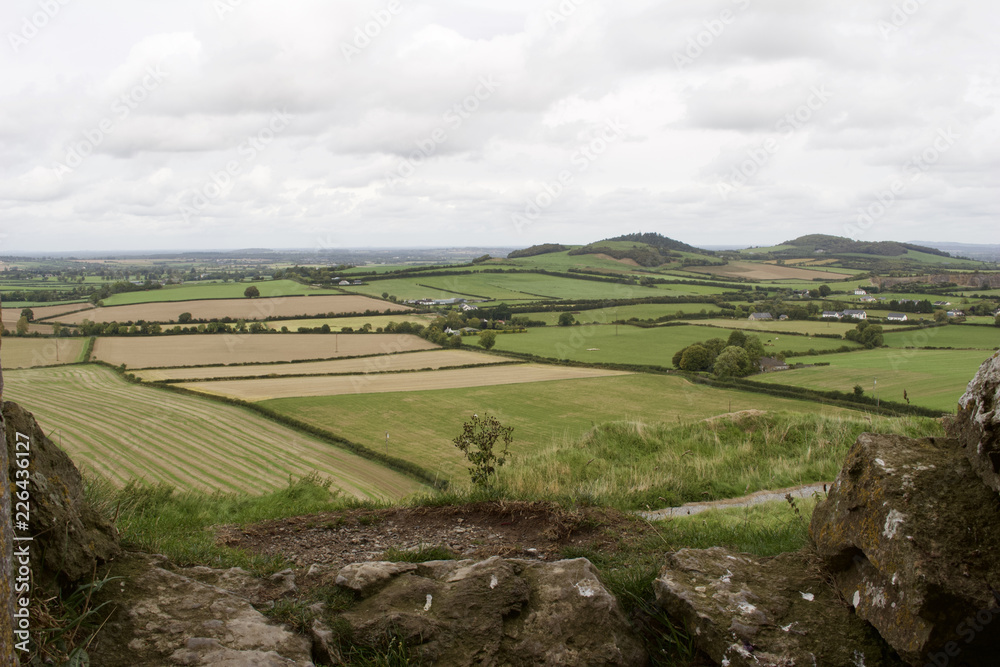 View of an Irish agricultural countryside with ancient stone ruins in the foreground