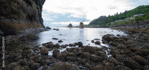 Pacific ocean coast at evening, overlooking Tillamook Bay, Oregon. Rock formations stick out of the still water. photo