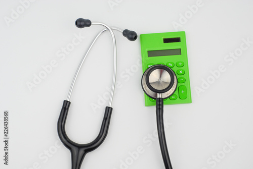 stethoscope and calculator on white background. Medical cost concept