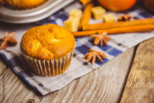 Homemade atutumn muffins with pumpkin, apples and spices on the rustic background. Selective focus.  photo