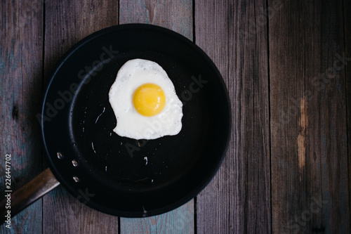 fried eggs in a frying pan on a wooden table, Breakfast, top view