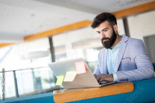 Portrait of young man sitting at desk in the office