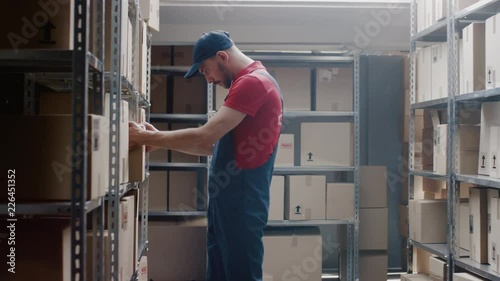 Wallpaper Mural Handsome Warehouse Worker Walks into Storeroom with a Cardboard Box and Puts it on a Shelf Torontodigital.ca