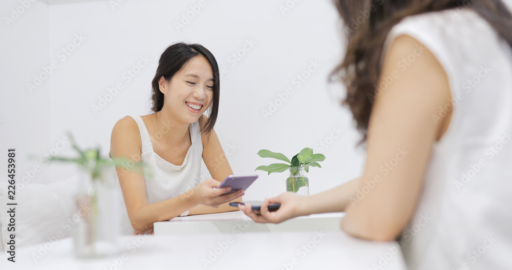 Friends sharing on cellphone inside coffee shop Friends sharing on cellphone inside coffee shop