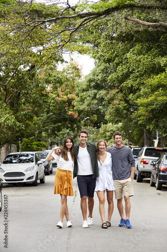Friend walking through street together, smiling