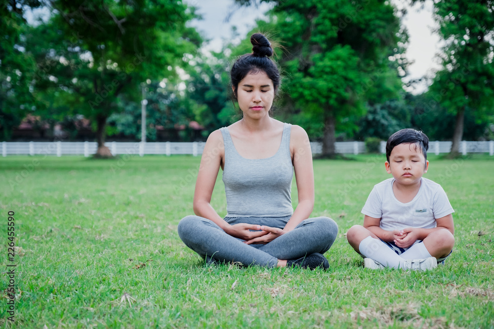 Fototapeta premium Mother and child meditation in park