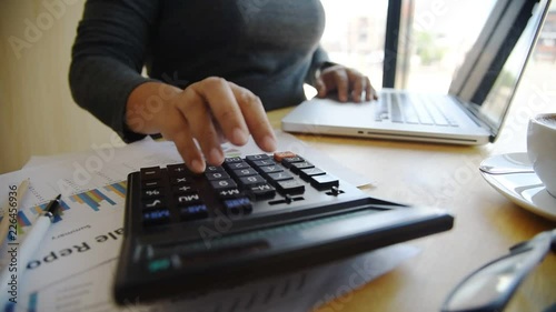 Businessmen are using a calculator to calculate the income of the business.