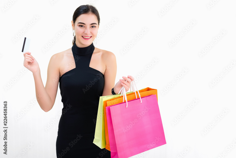 Attractive young businesswoman enjoy shopping online with full of bags with credit card, standing on white background. Have a colorful shopping bags hold on hand. Attractive young businesswoman enjoy shopping online with full of bags with credit card, standing on white background. Have a colorful shopping bags hold on hand.