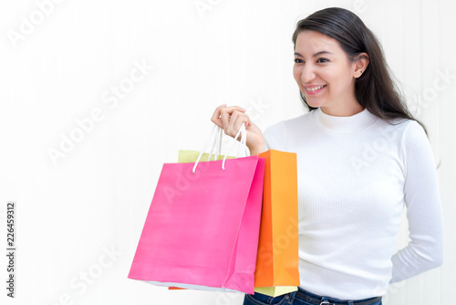 Beautiful attractive Asian female enjoy shopping with full of bags on sale with happiness and joyful. Studio shot on white background. 