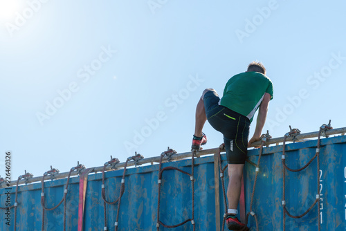 Athlete climbing over a container at an obstacle course race  photo
