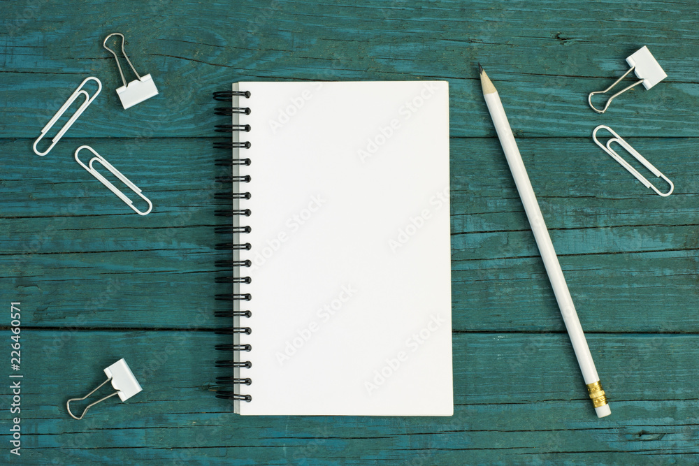White cardboard pencil and paper clips on wooden desk White cardboard pencil and paper clips on wooden desk
