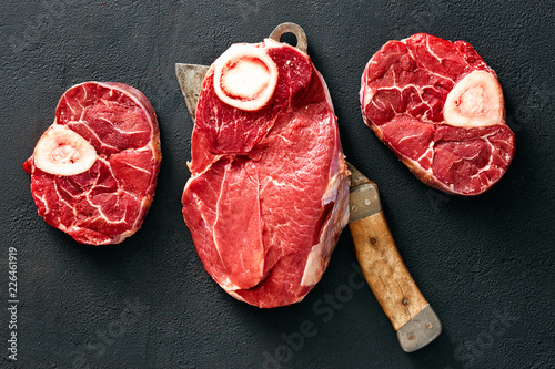 Bone beef meat butcher knife black background top view