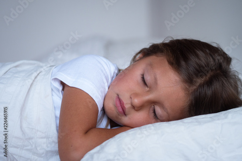 Portrait of a young girl (kid) sleeping on the bed. Concept: Relax, family