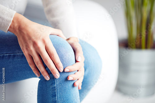 Physical injury of leg / knee / joint - woman holding painful part body. photo