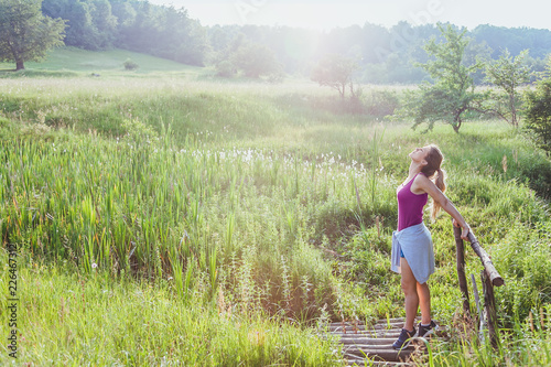 Young woman doing exercise in the nature at sunset