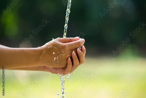 Water pouring in people hand on nature background environment issues.Health care concept.